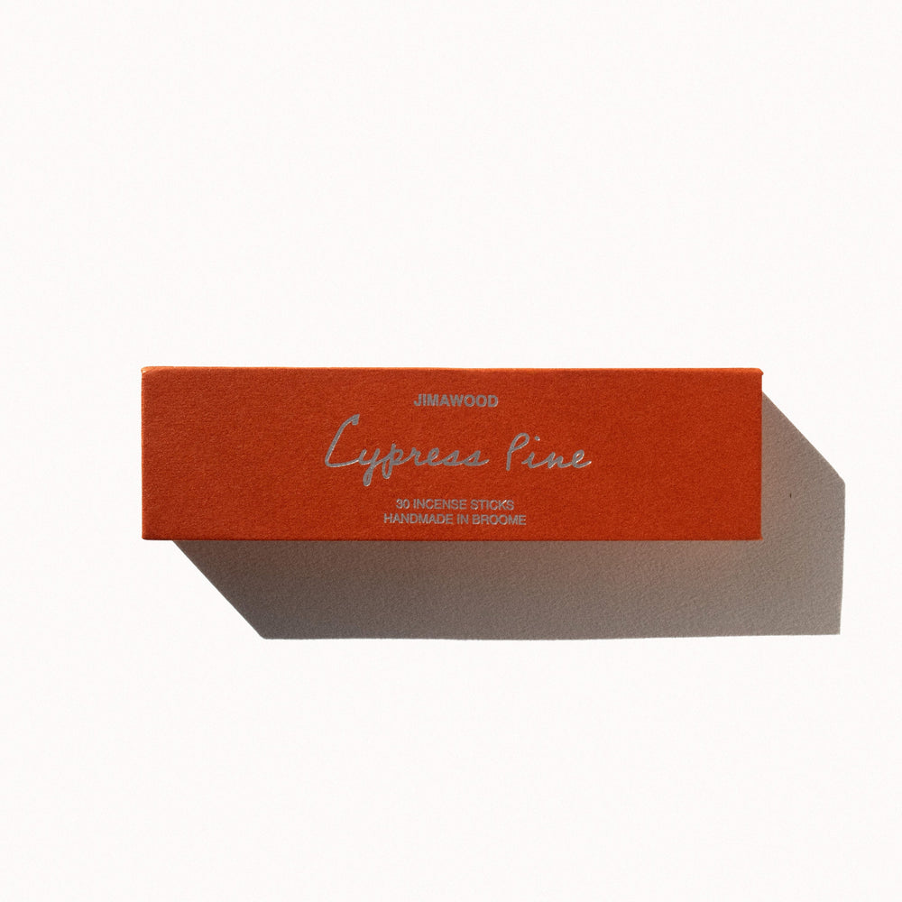 An orange cardboard box on a plain background. Text on the box: Jimawood Cypress Pine 30 Incense Sticks Handmade in Broome