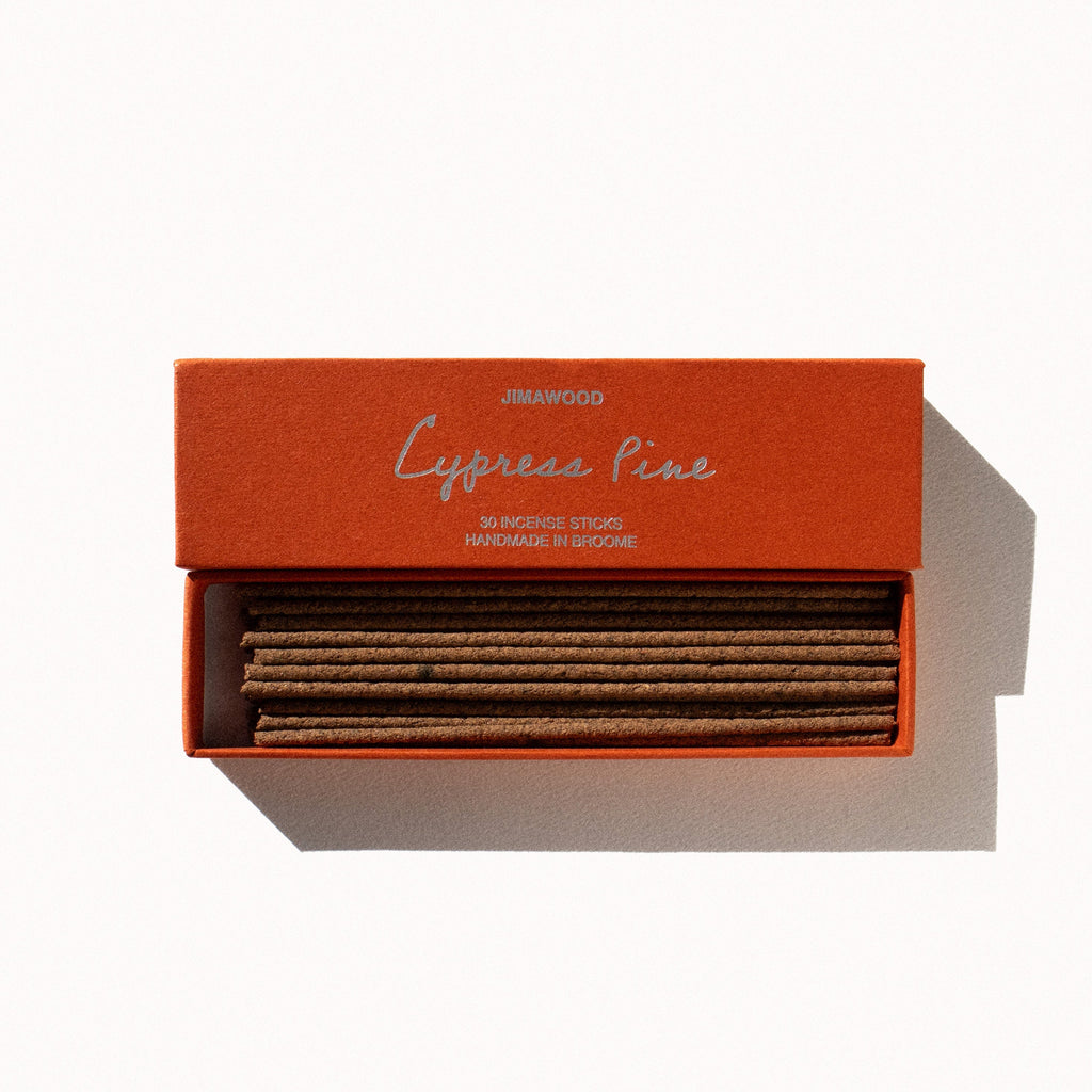 An orange cardboard box slightly opened on a plain background. Text on the box: Jimawood Cypress Pine 30 Incense Sticks Handmade in Broome