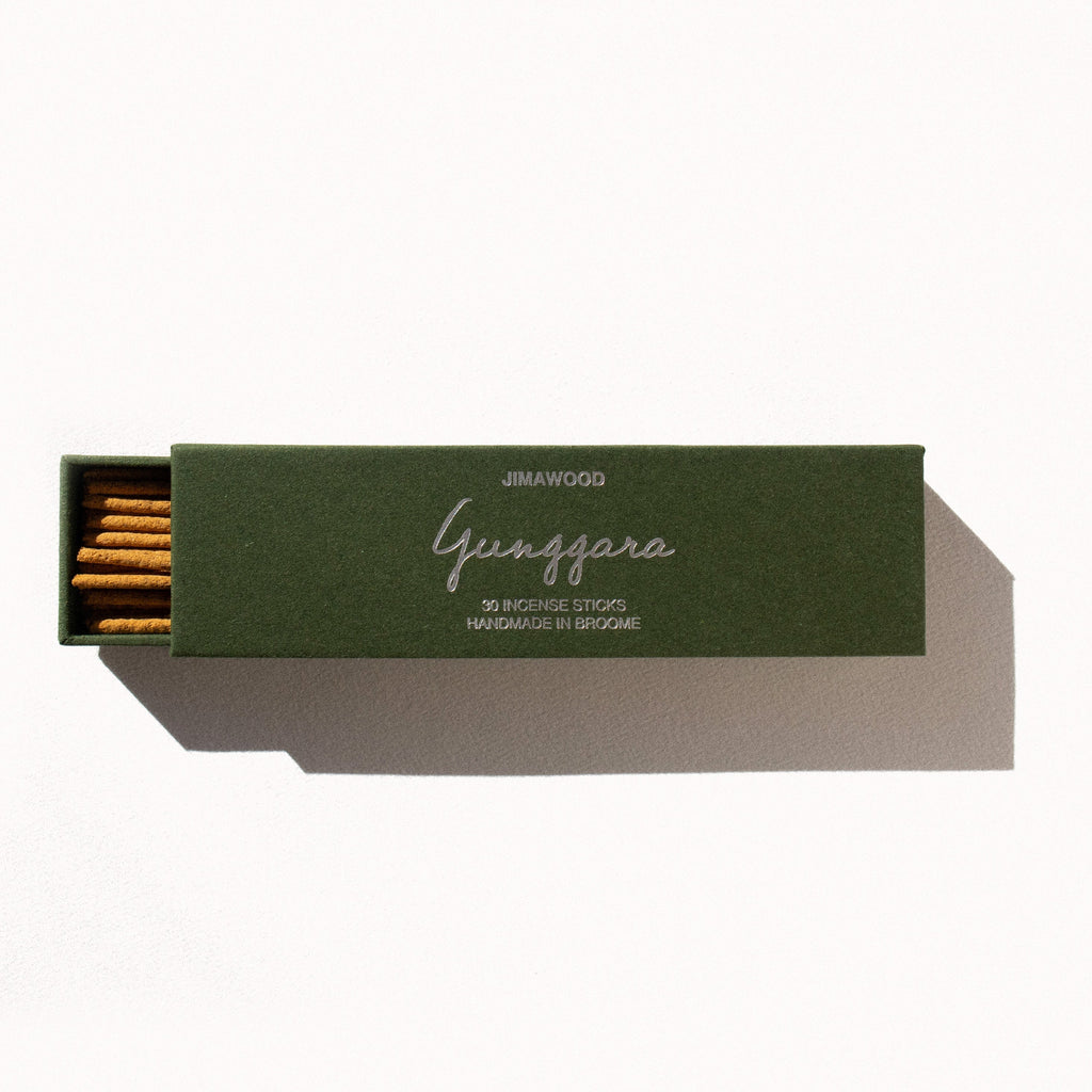 A green cardboard box slightly opened on a plain background. Text on the box: Jimawood Gunggara 30 Incense Sticks Handmade in Broome